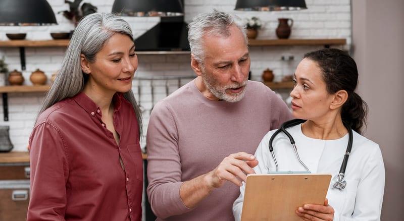 A clinician reviewing a care plan with an older couple